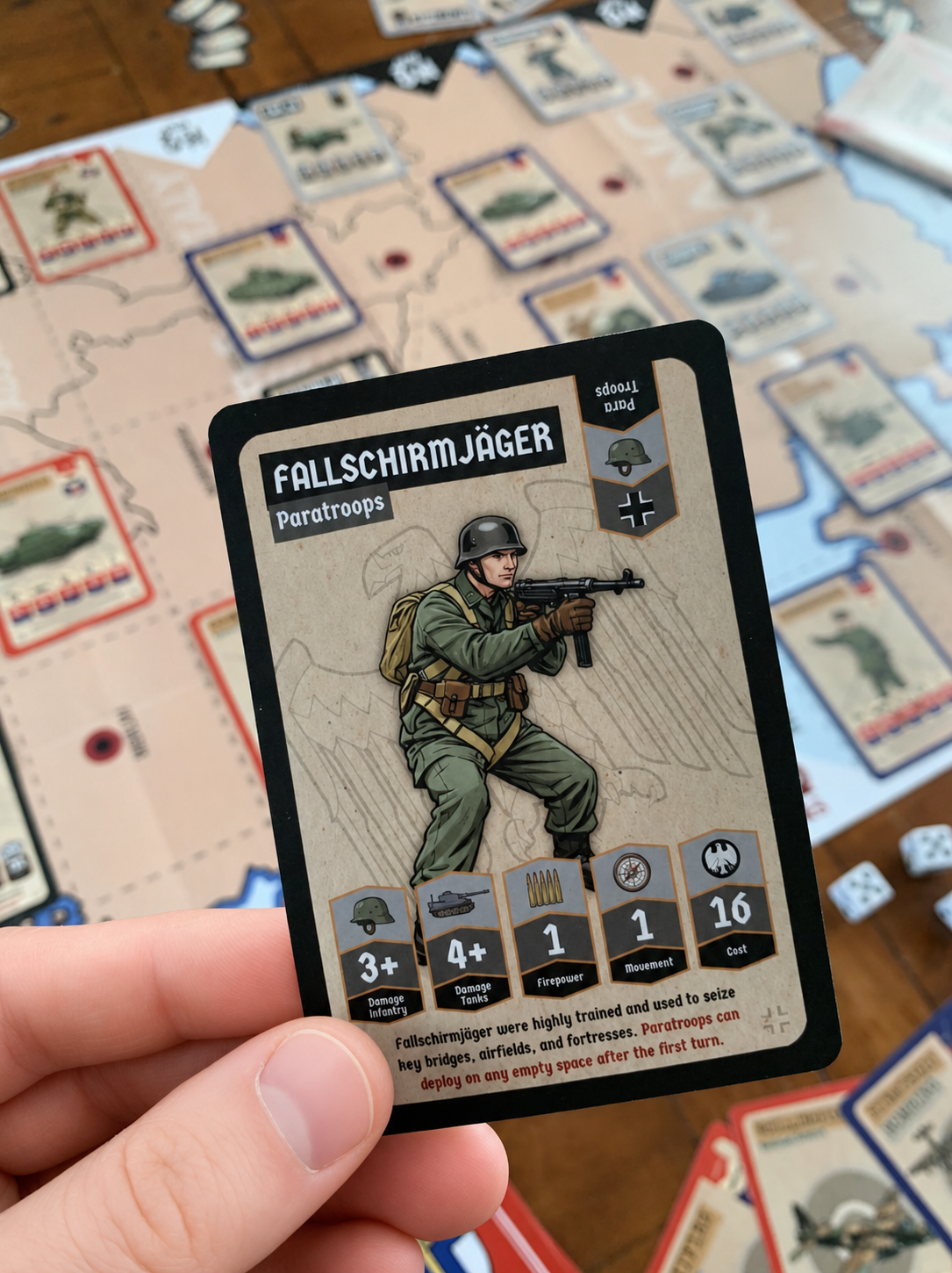 Card featuring a german paratrooper character held over a ww2 game board with other cards.