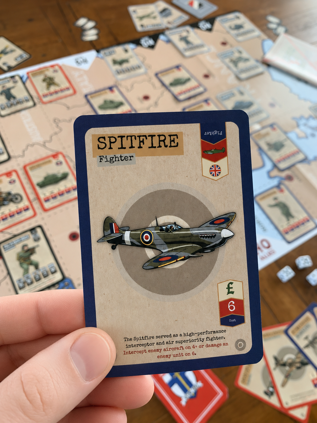 Card featuring a Spitfire fighter plane held over a world war II board game with other cards.